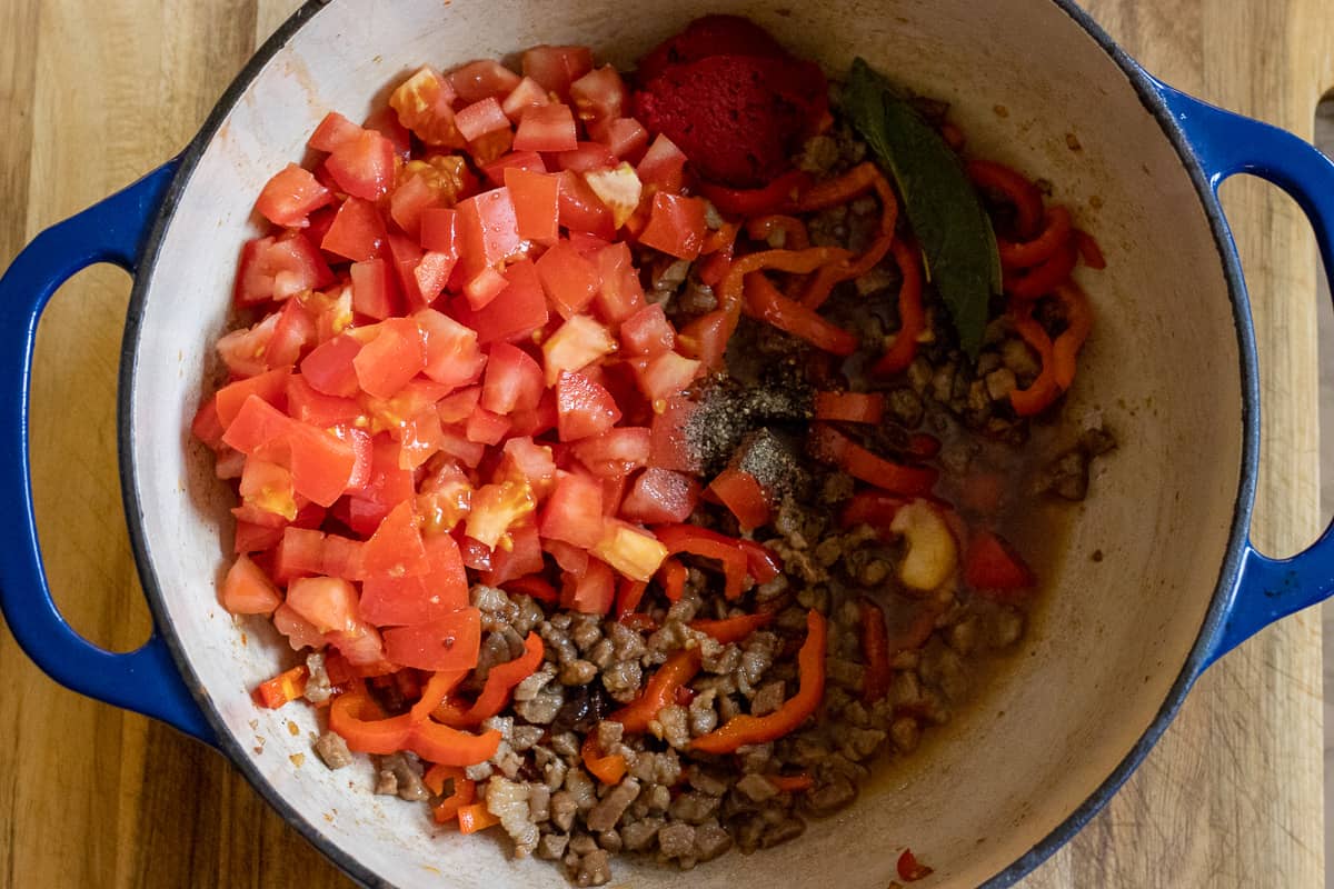 tomatoes, tomato paste, stock and seasoning are added to the lamb