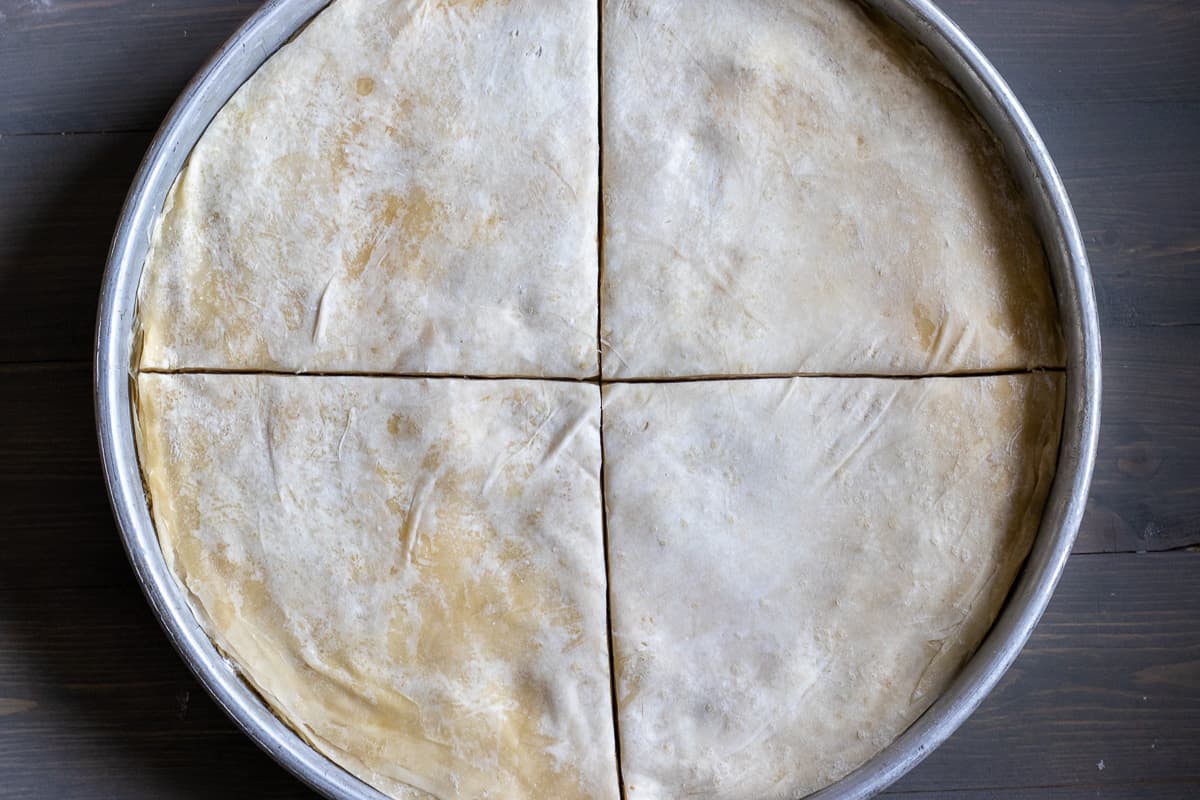 a tray of authentic Middle Eastern walnut baklawa is cut into 4 equal pieces