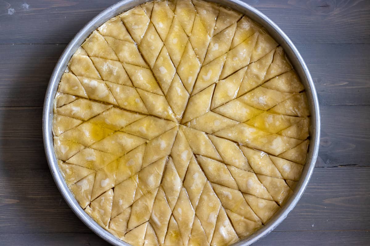 butter and oil mixture is poured on top of baklawa