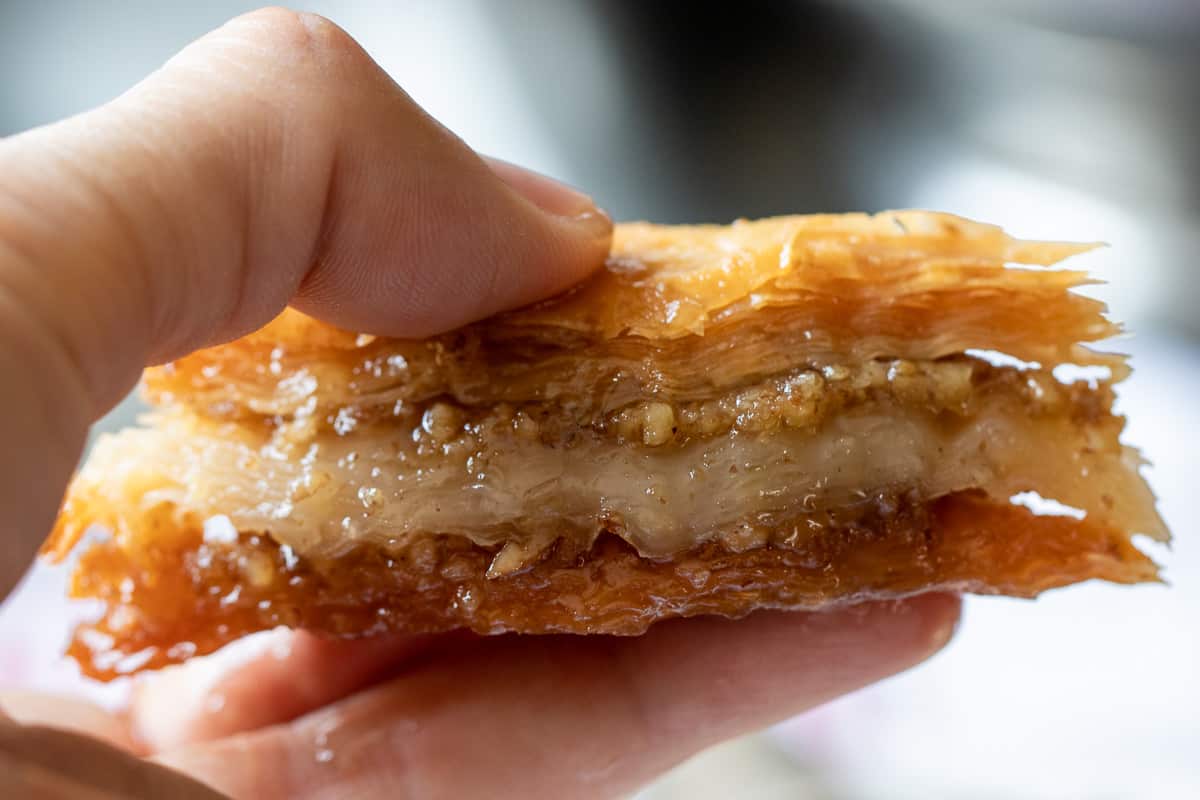 holding a piece of authentic Middle Eastern walnut baklawa