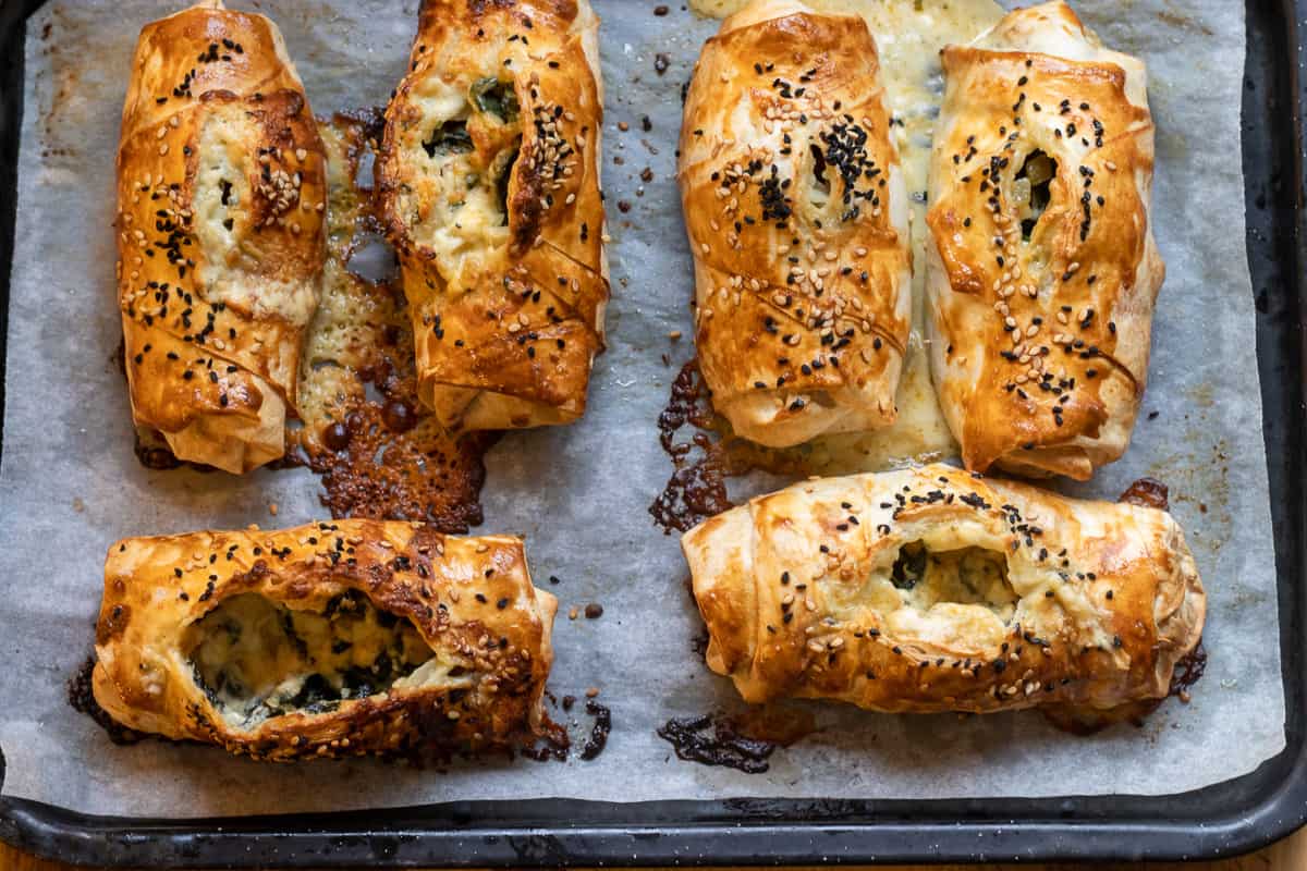 6 pieces of spinach and feta pie on a baking sheet