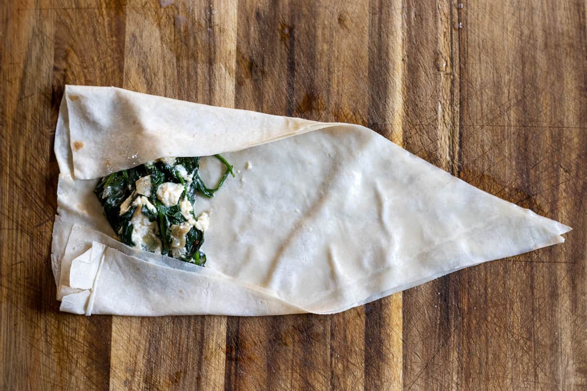 both sides of yufka triangle are folded over the filling