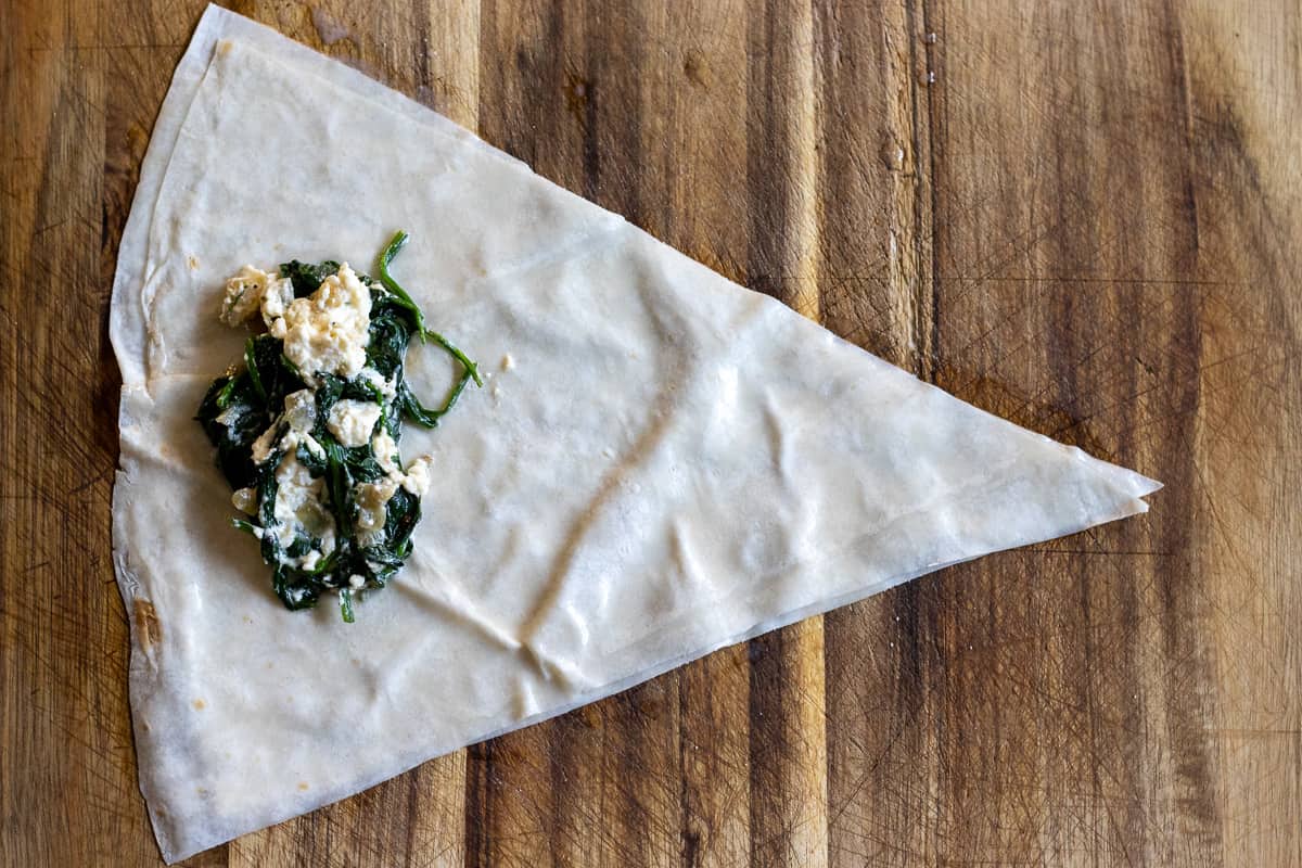 2 tablespoon of spinach filling is placed on yufka