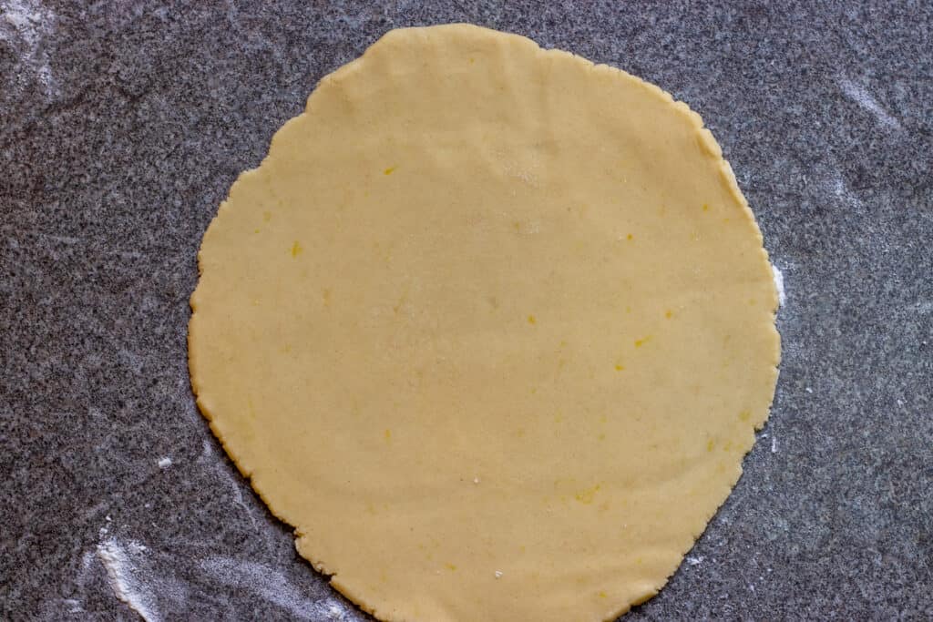 A dough ball is rolled out into a circle.
