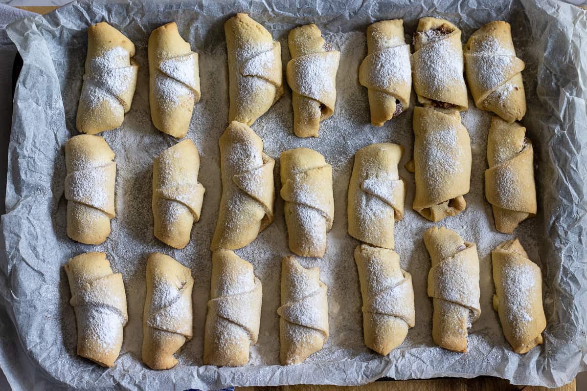 baked apple cookies are dusted with icing sugar