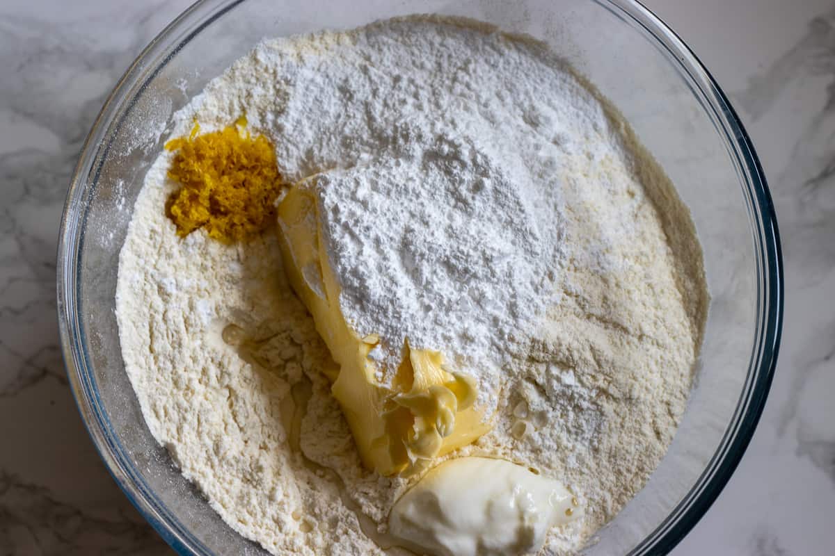 flour, sugar, butter and lemon zest are placed in a bowl