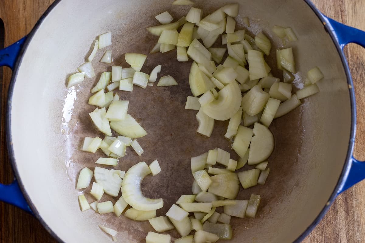 sautéing chopped onions with olive oil in a dutch oven