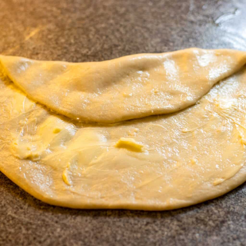 Start folding the dough to turn it into a parcel.