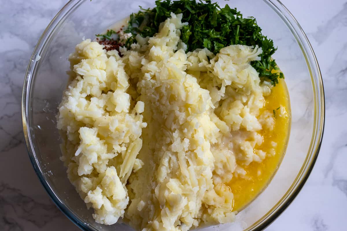 grated potatoes, cheese and chopped parsley are added to milk sauce