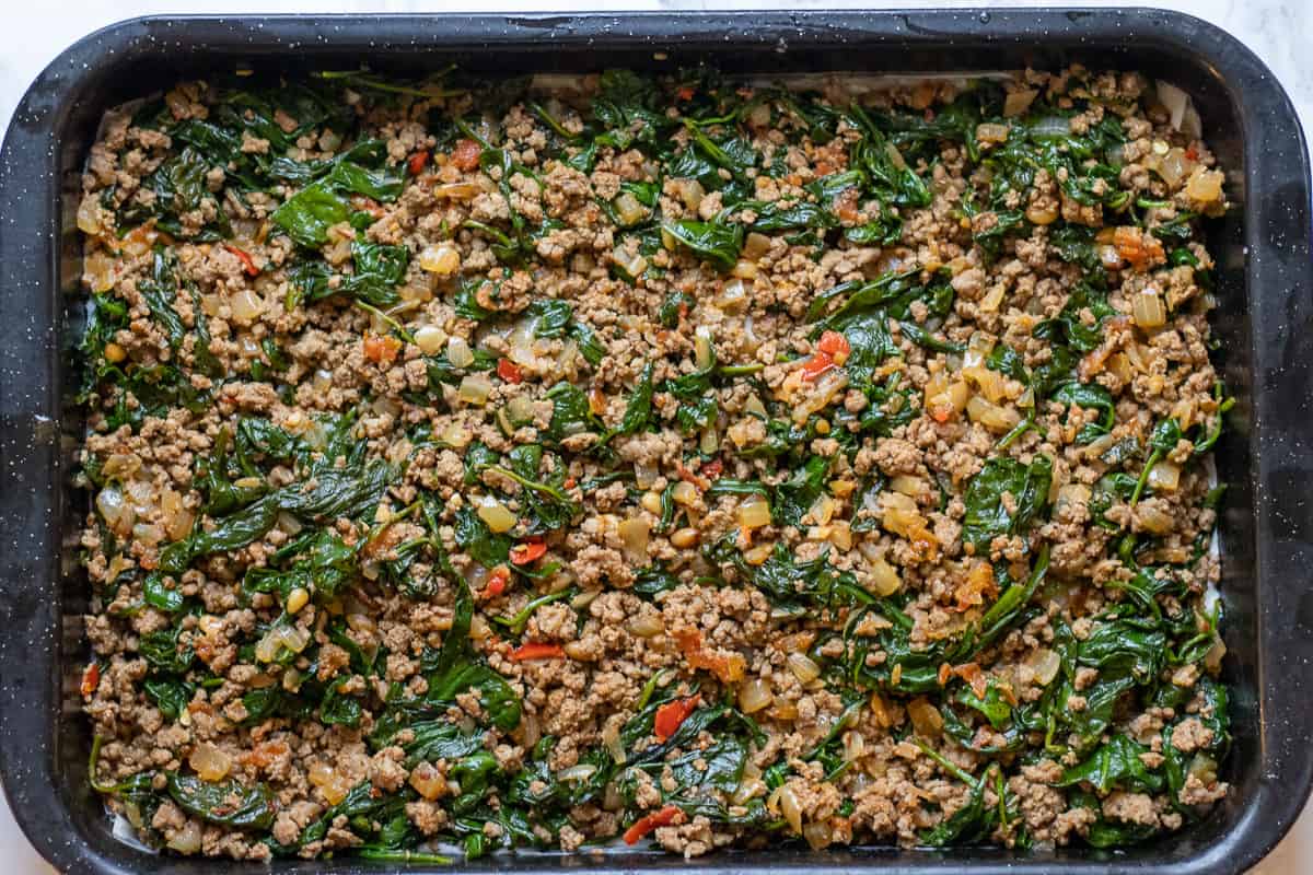 meat and Spinach fulling is spread on top of filo pastries