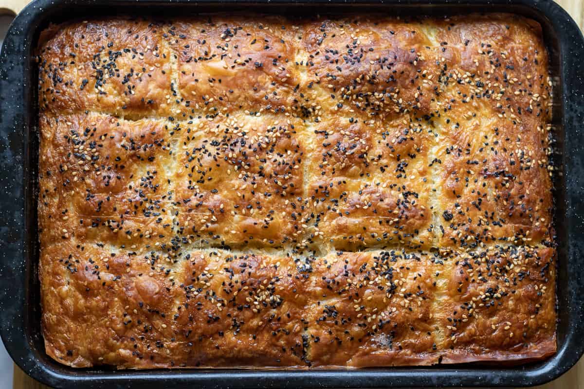 meat and spinach phyllo pie is baked until golden and crispy