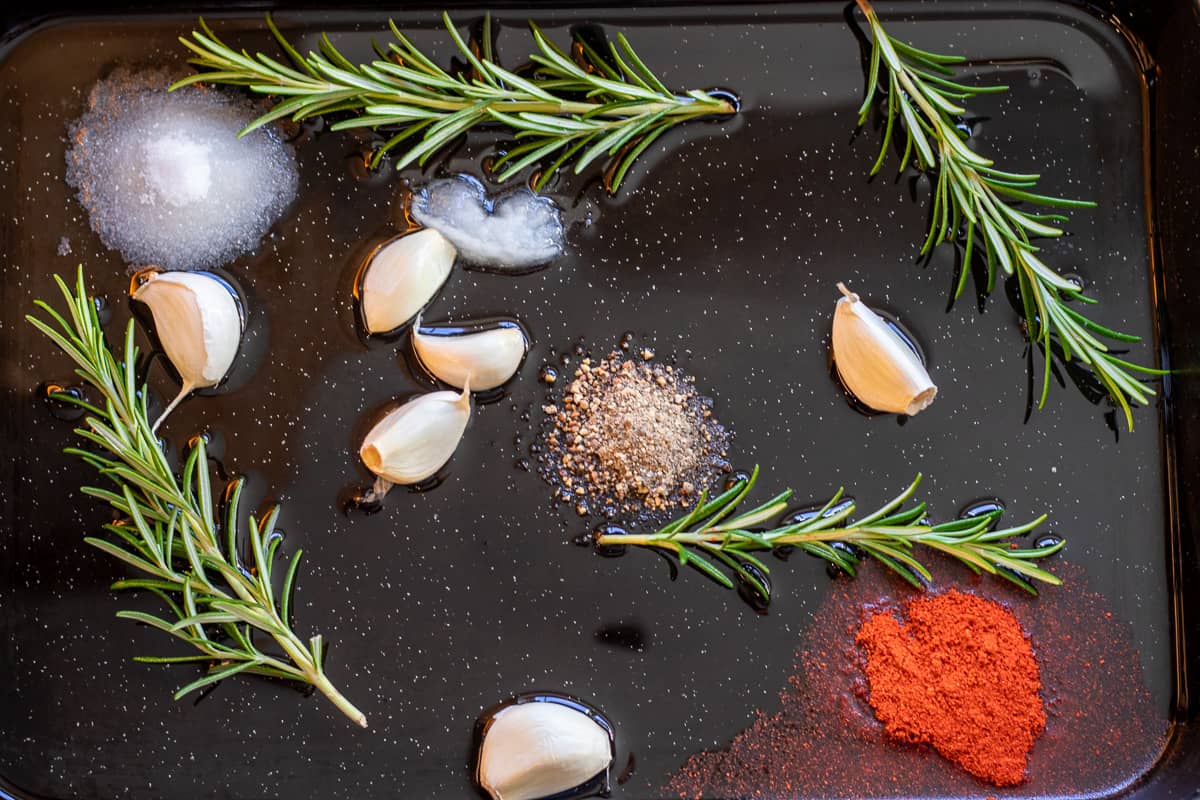 garlic, rosemary, seasoning and duck fat are placed on a baking sheet