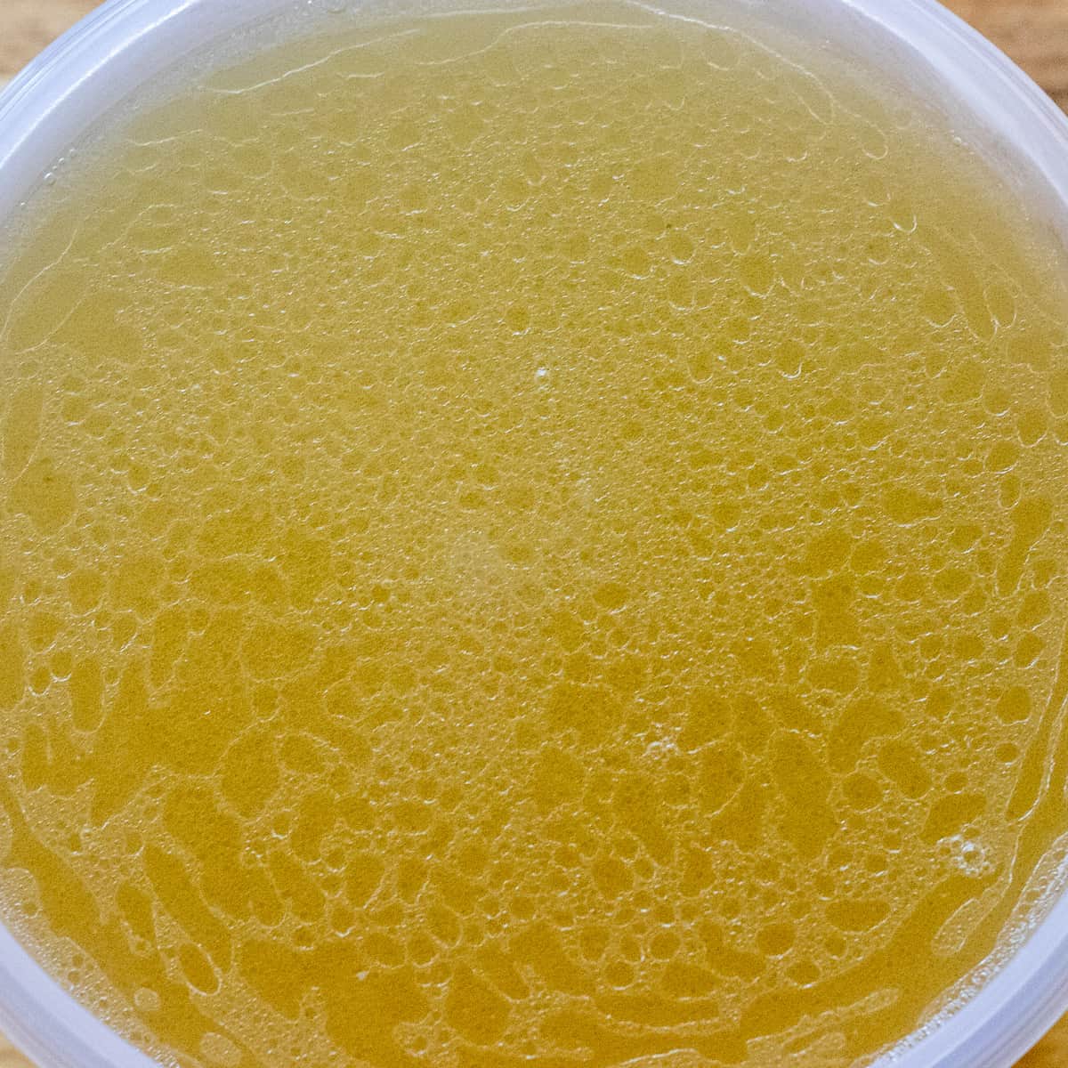 chicken stock is passed through a sieve and cooling down before placing in jars