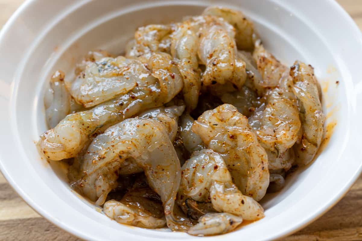 Raw tiger prawns shelled, cut in halves and marinated with olive oil and cajun spices.