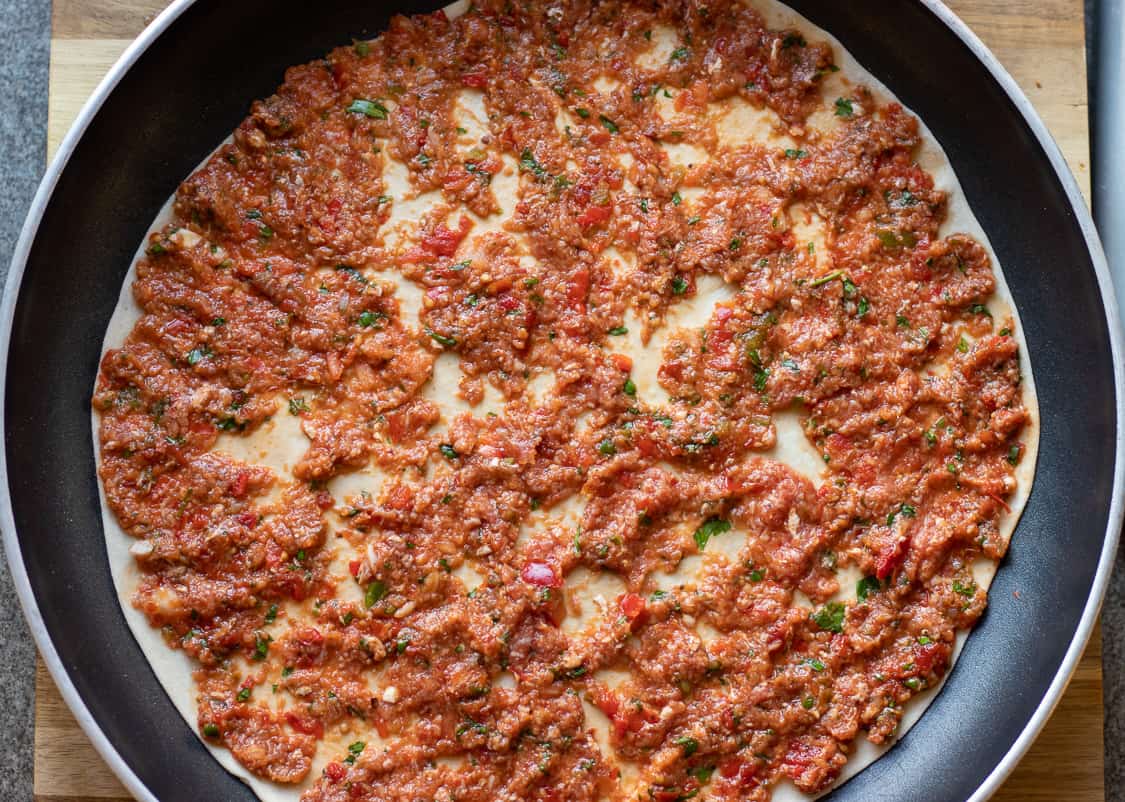 Homemade Turkish lahmacun cooking on a pan