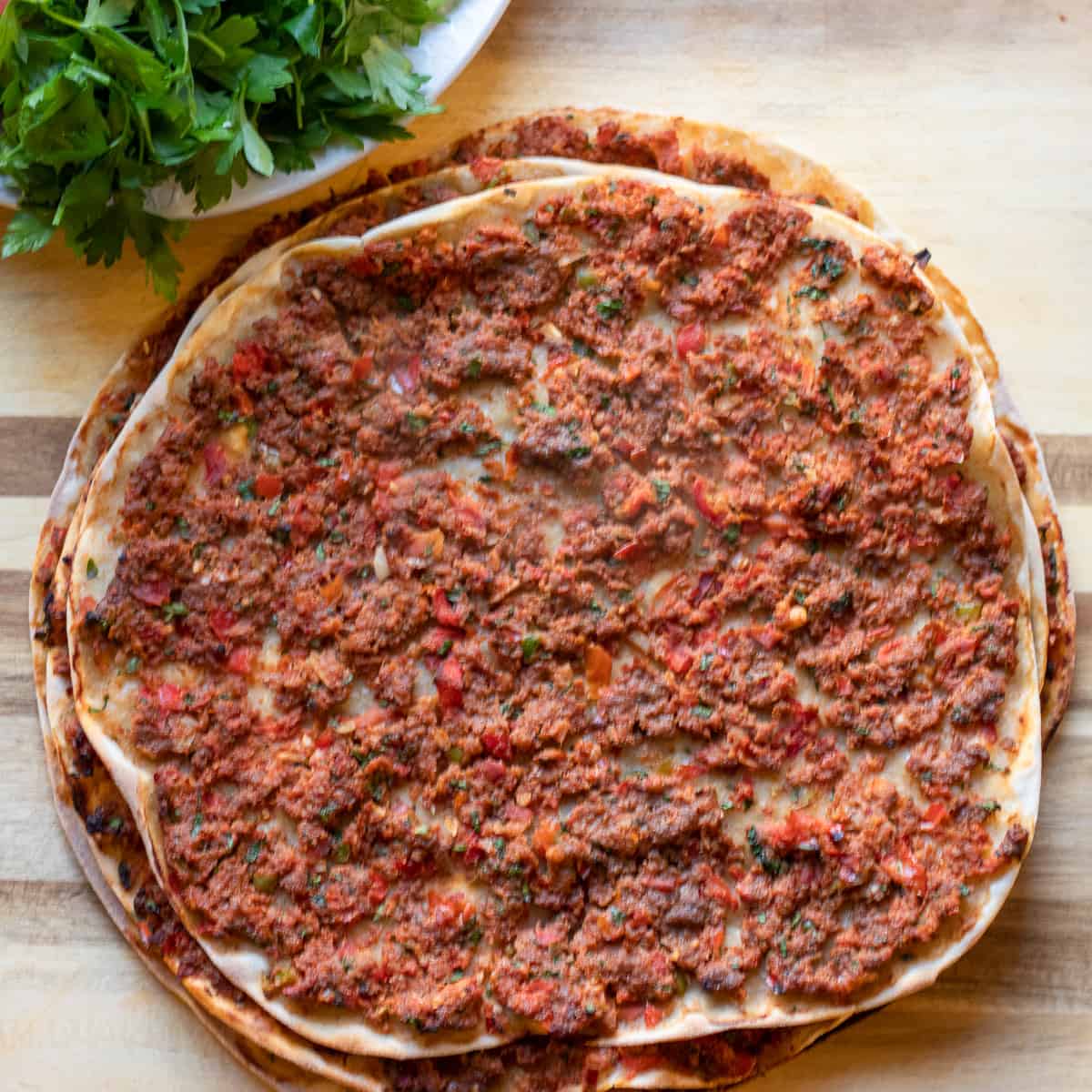 cooked lahmacun are stacked together to keep them warm