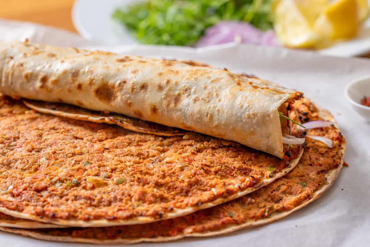lahmacun wrapped with parsley and tomatoes