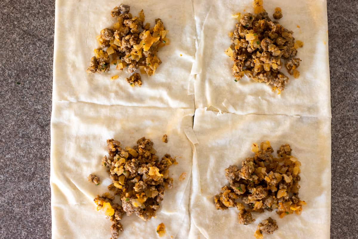 a spoonful of mince filling is placed on each square