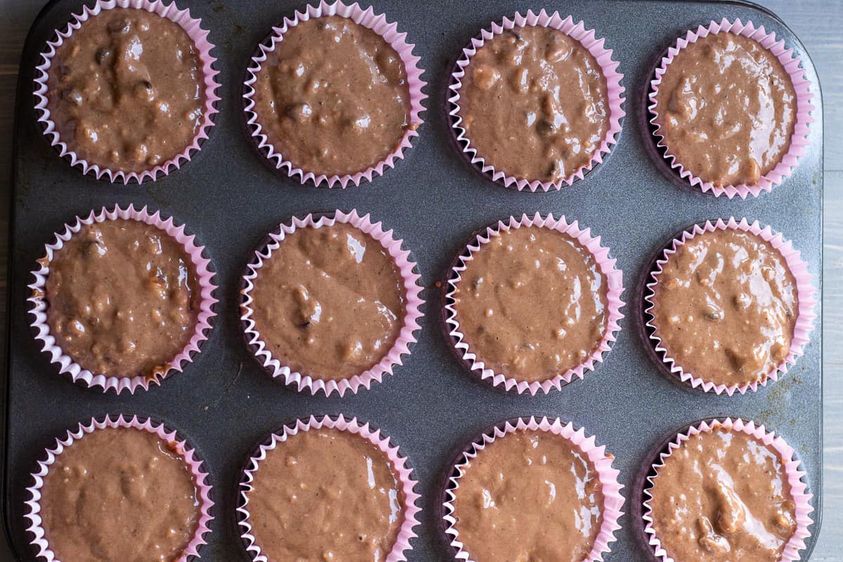 The muffin batter is equally filled in 12 muffin cases.