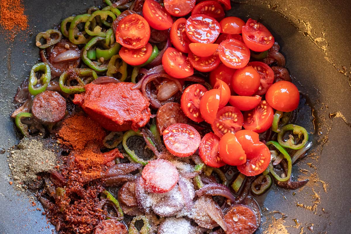 adding the tomatoes, tomato paste and seasoning