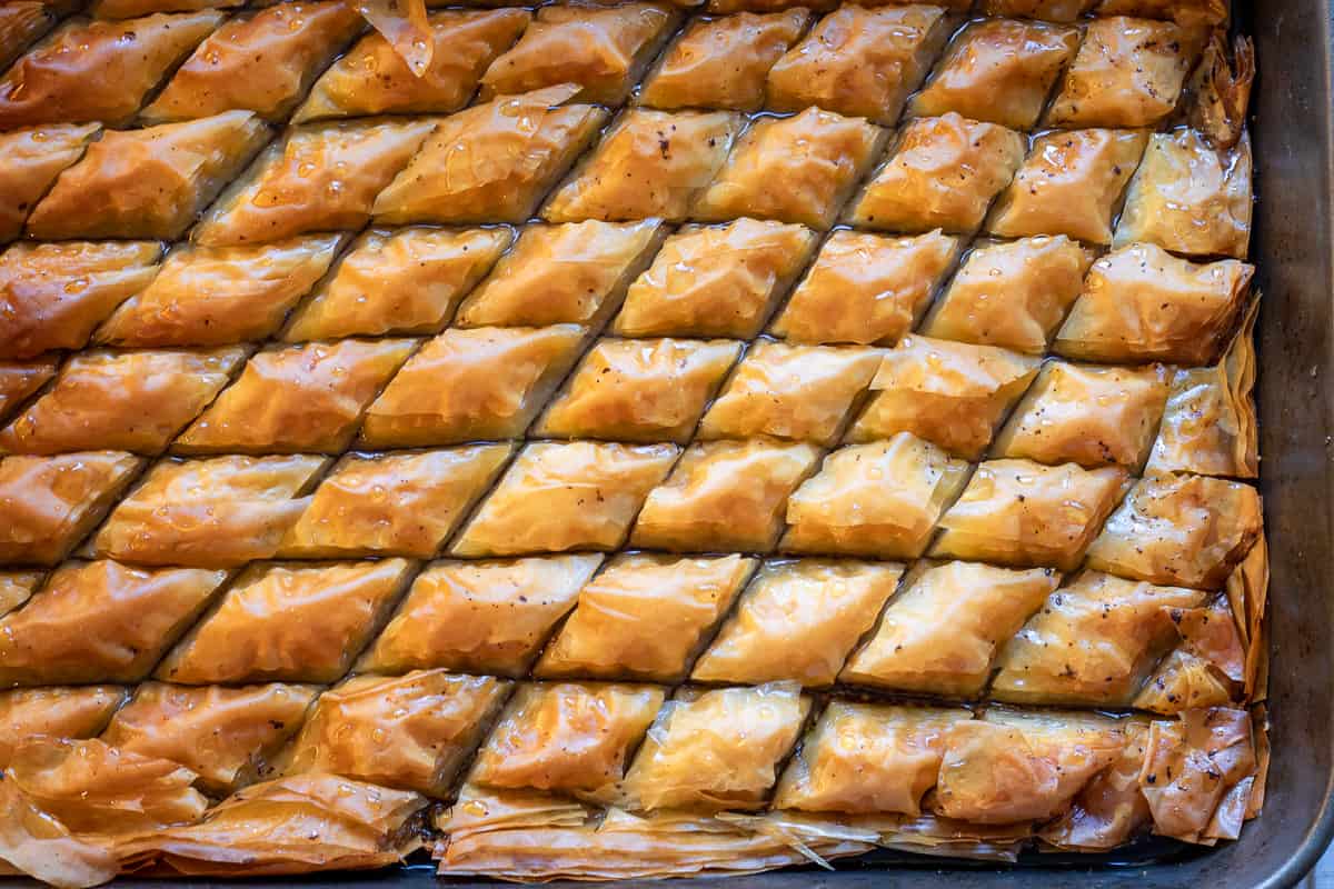 the syrup is poured over the baklava and let it soak overnight