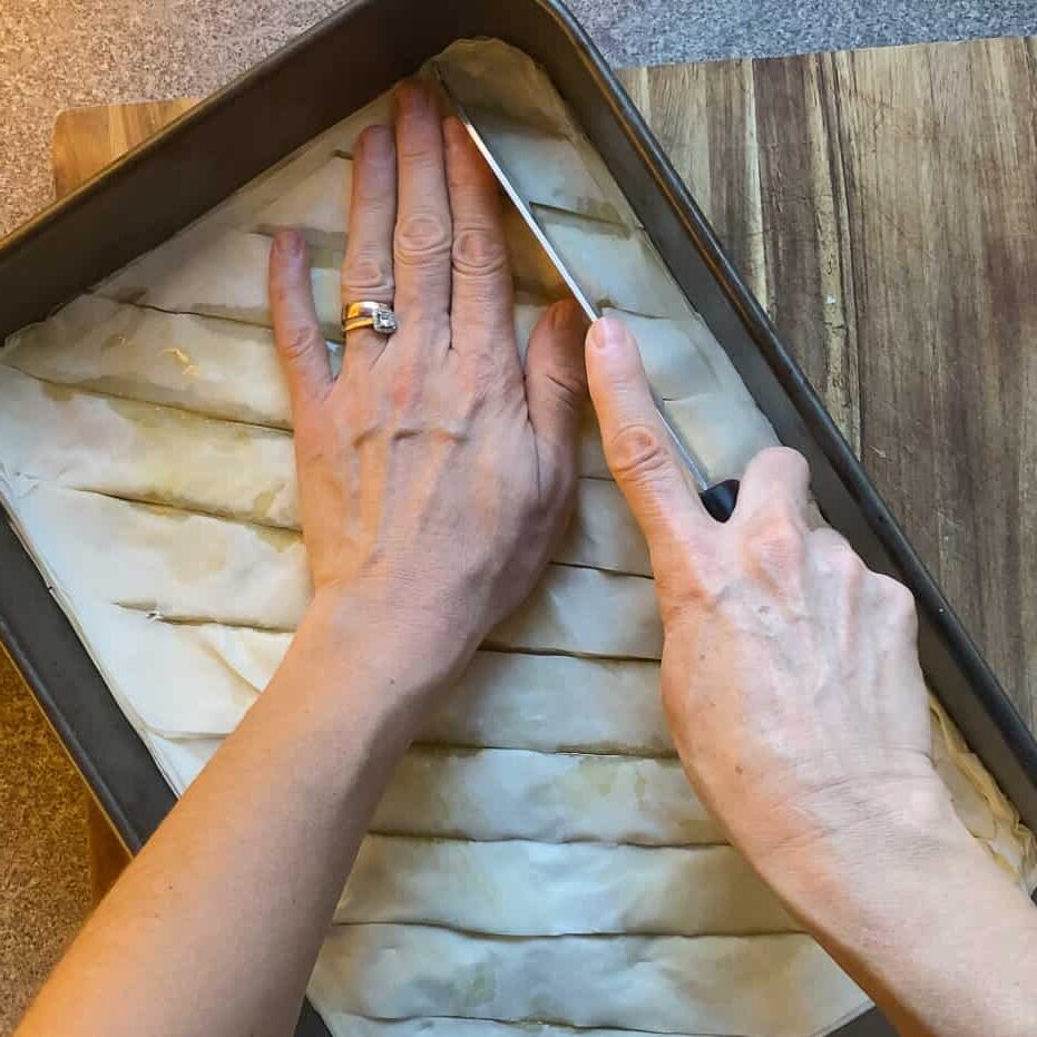cutting the baklava in vertical strips to have diamond shaped baklava