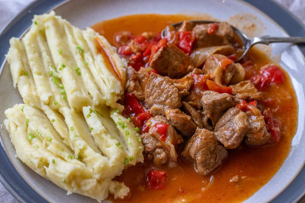 lamb goulash served with mashed potatoes