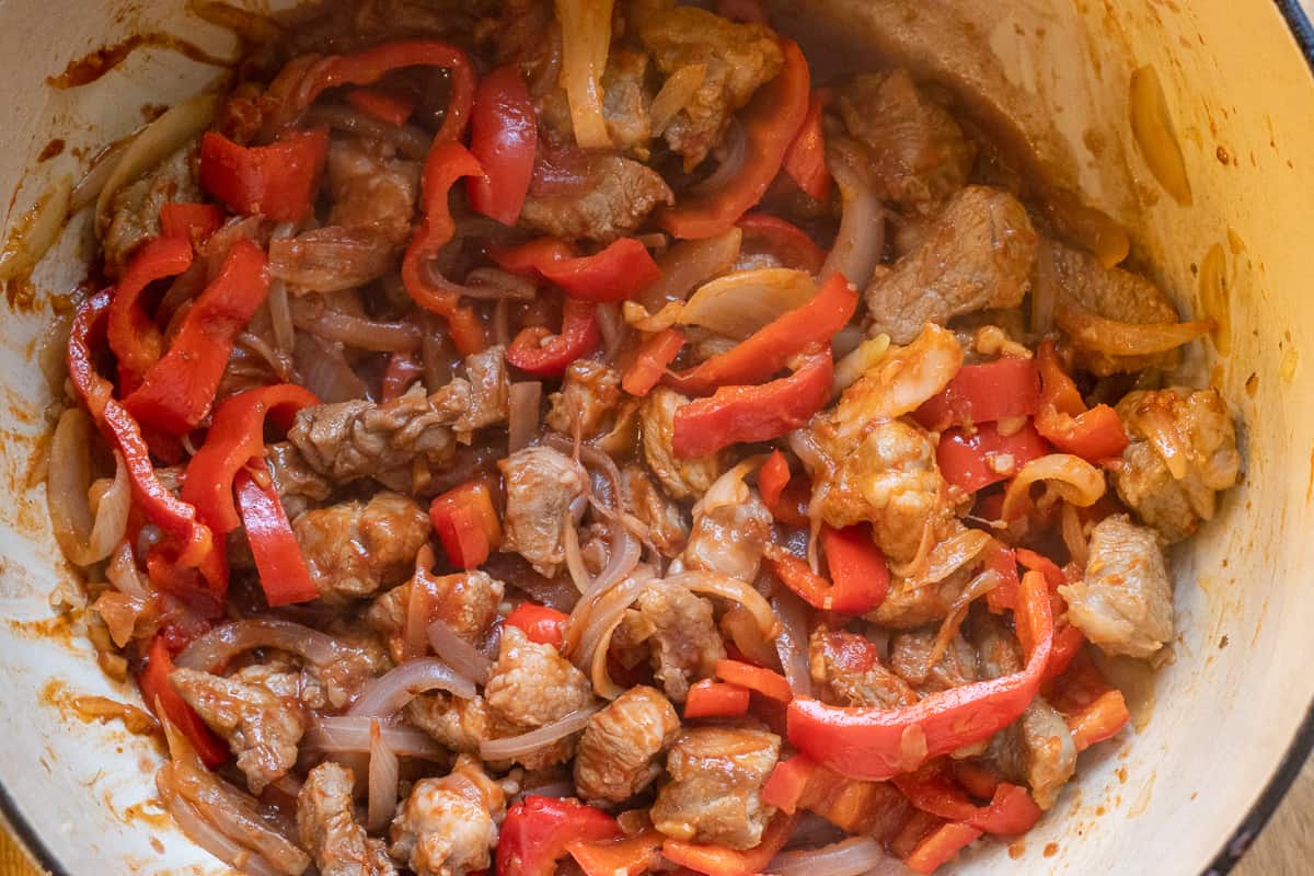 red wine is added to sautéed lamb and onions