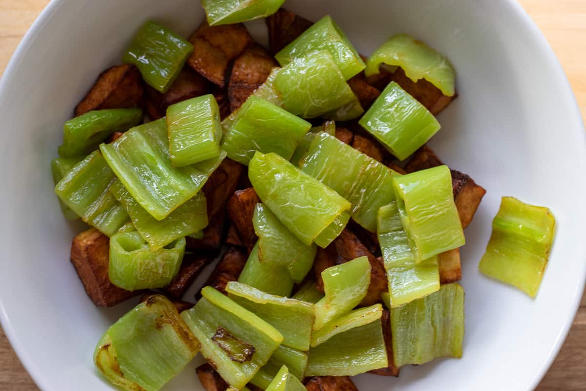 fried peppers are added to the potatoes