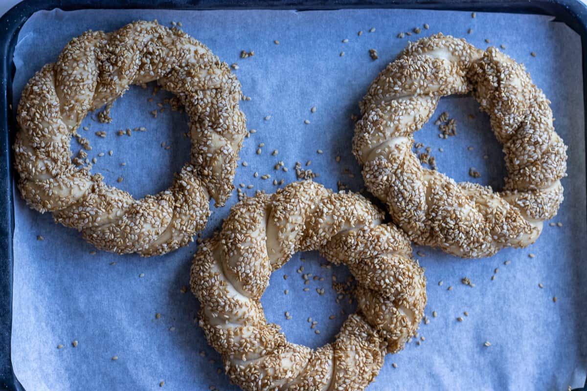 3 pieces of simit on a tray lined with baking paper