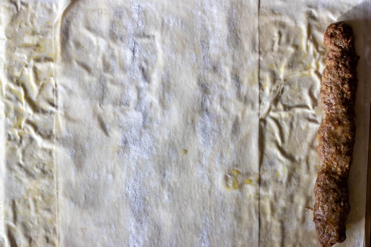 a piece of kofte is placed on filo pastry