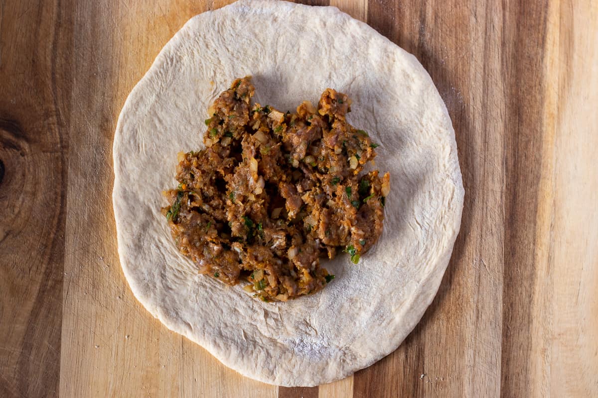The filling is placed into the middle of the dough circle