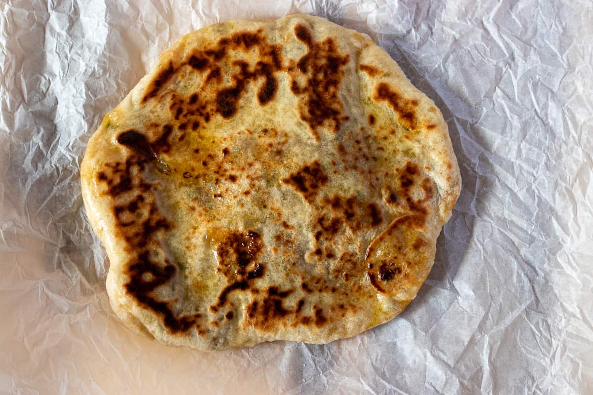 Freshly cooked naan is brushed with ghee or butter