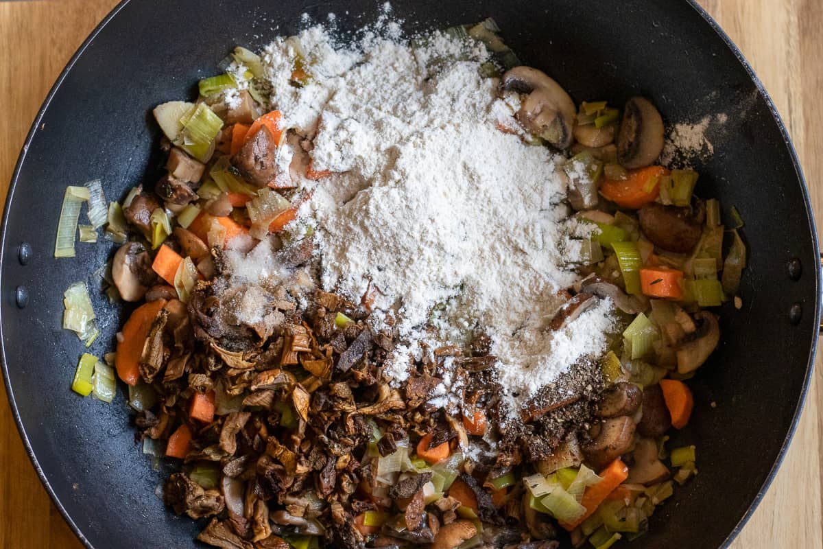the flour, wild mushrooms and seasoning are added to the pan