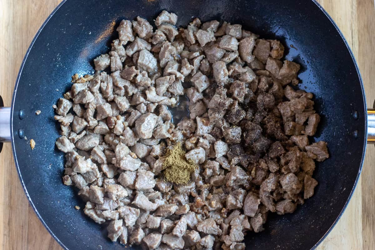 the spices are added to sautéed lamb
