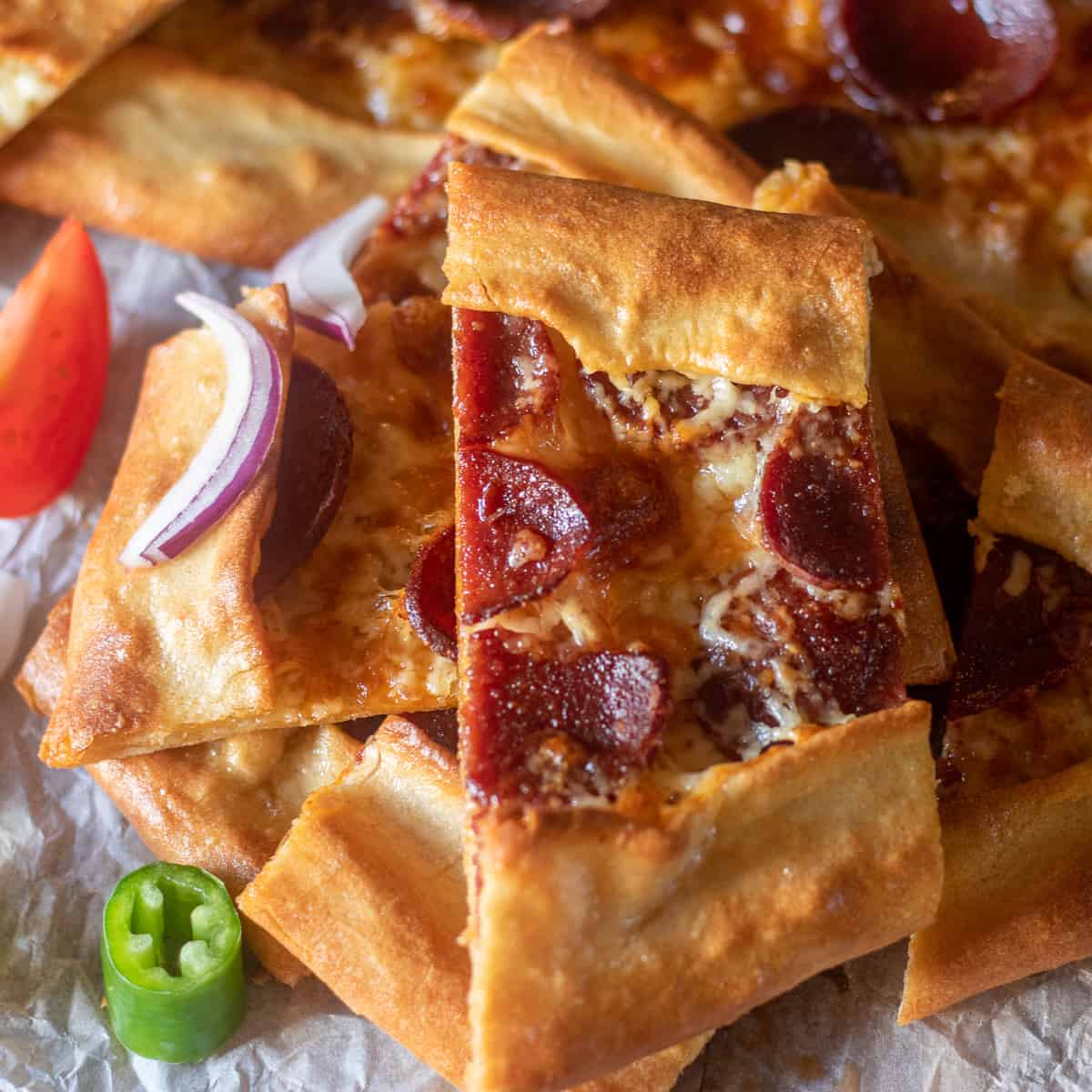 sucuklu pide (Turkish Bread with Spicy Sausage) sliced and served with fresh vegetables