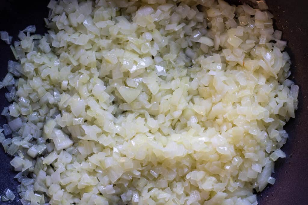 Sautéing the onions with olive oil in a wok.