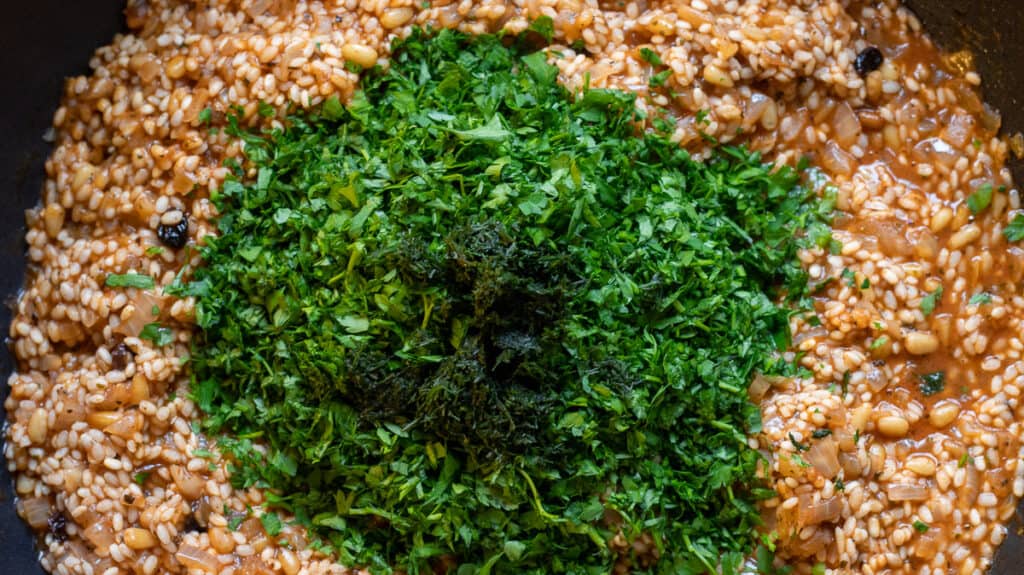 Fresh herbs are added to rice mixture.