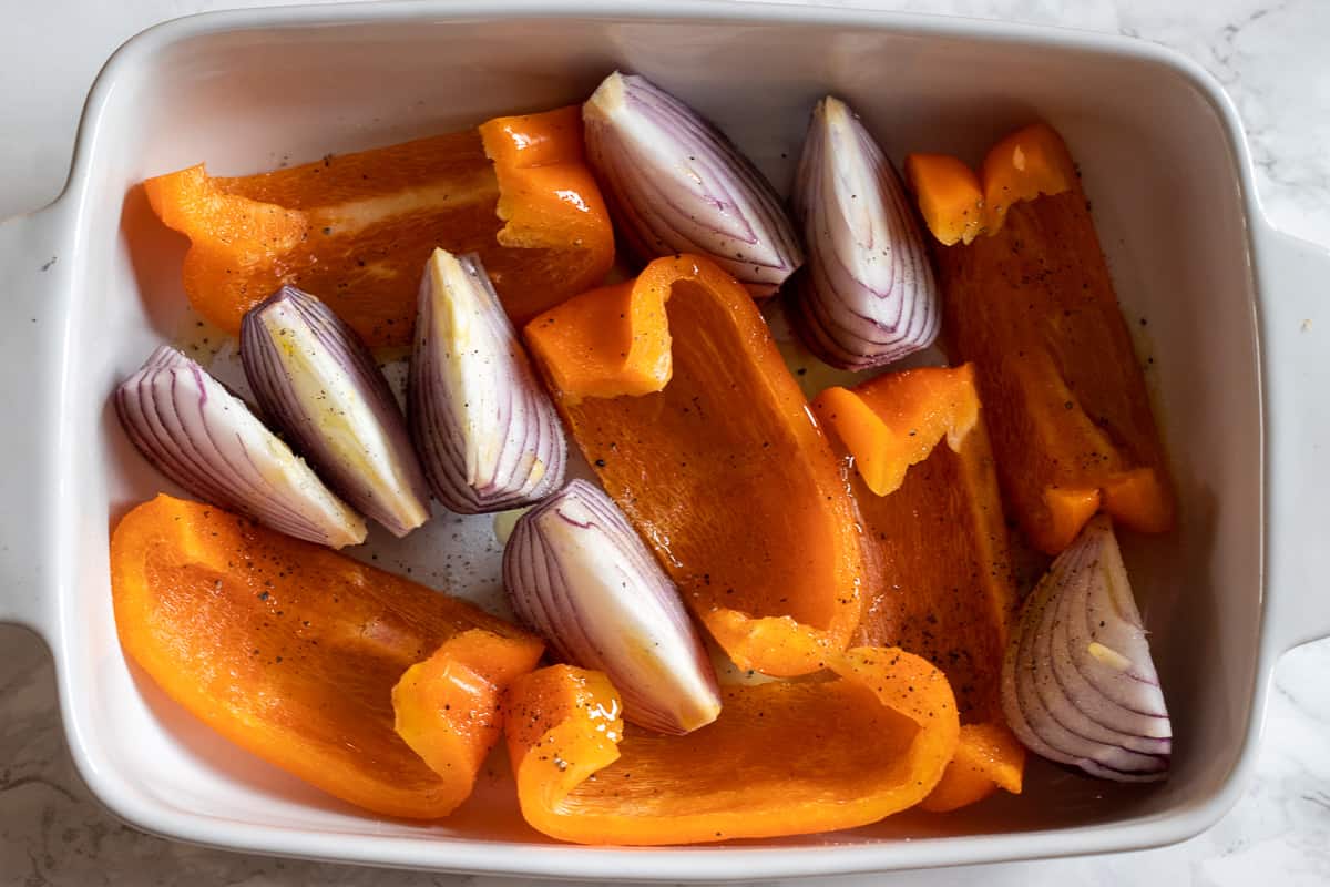 the onions and peppers are placed in an oven dish