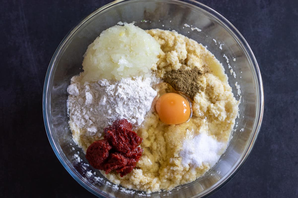 Egg, onions, tomato paste and spices are added to bulgur mixture