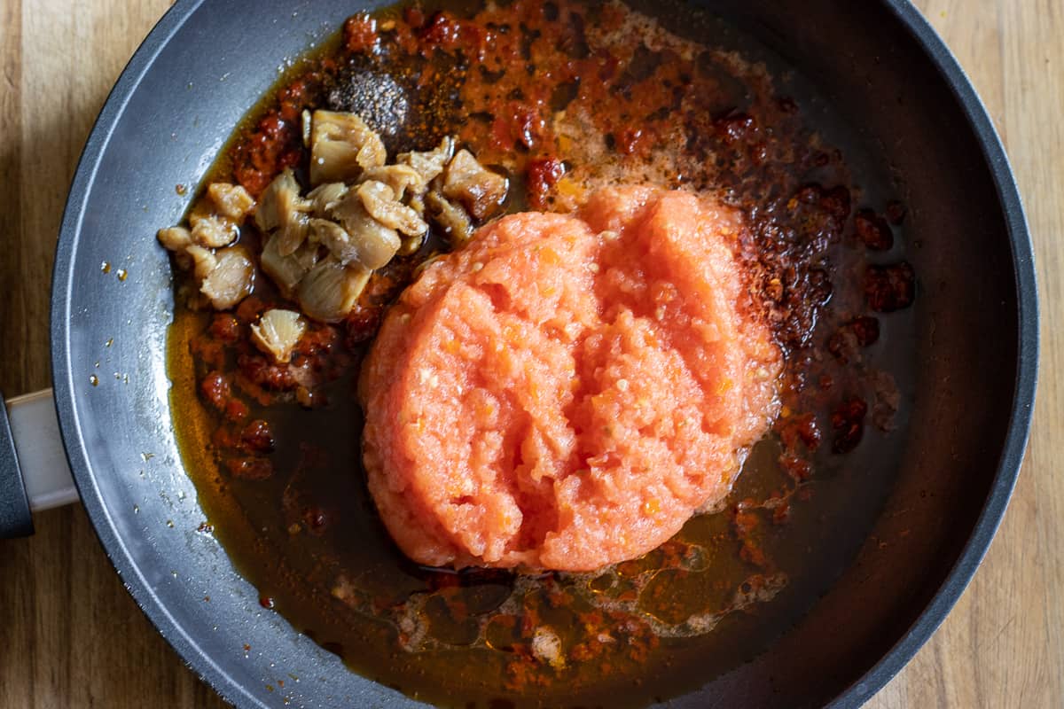 garlic, grated tomato and spices are added to the pan