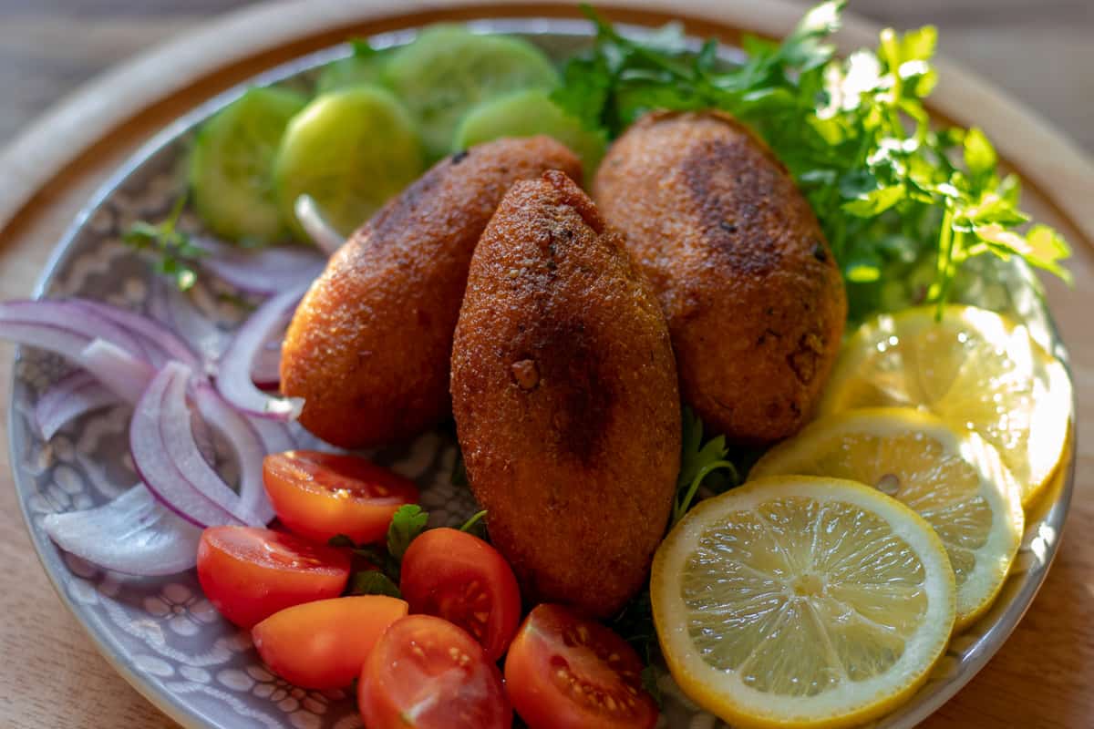 3 kibbeh served with salad and lemon slices