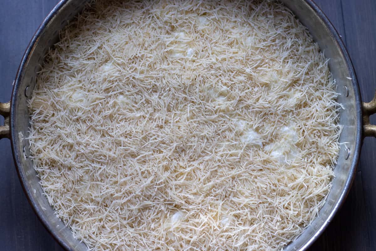 the rest of the kadaif is scattered on top of the cheese and pressed