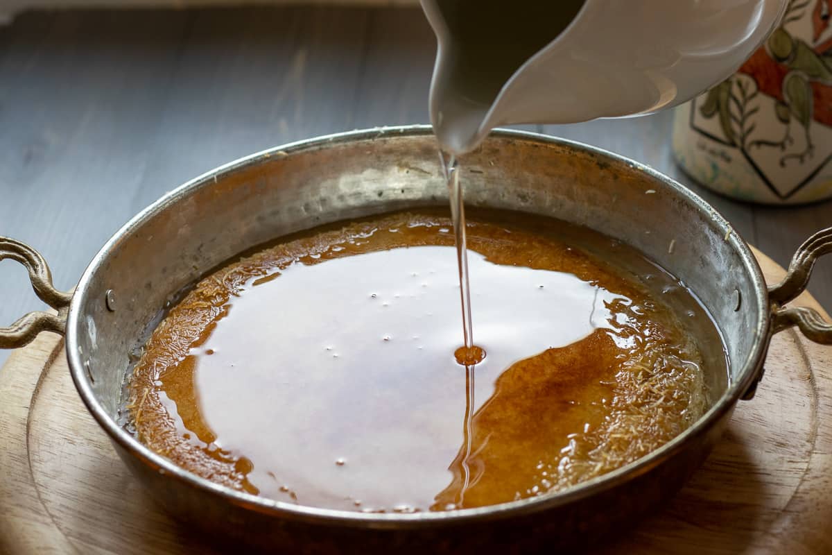 Driszzling sweet syrup on kunefe