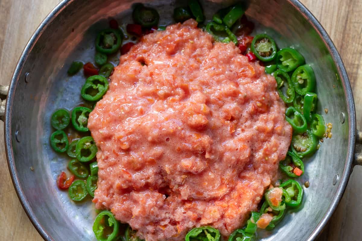 add grated tomatoes to the pan