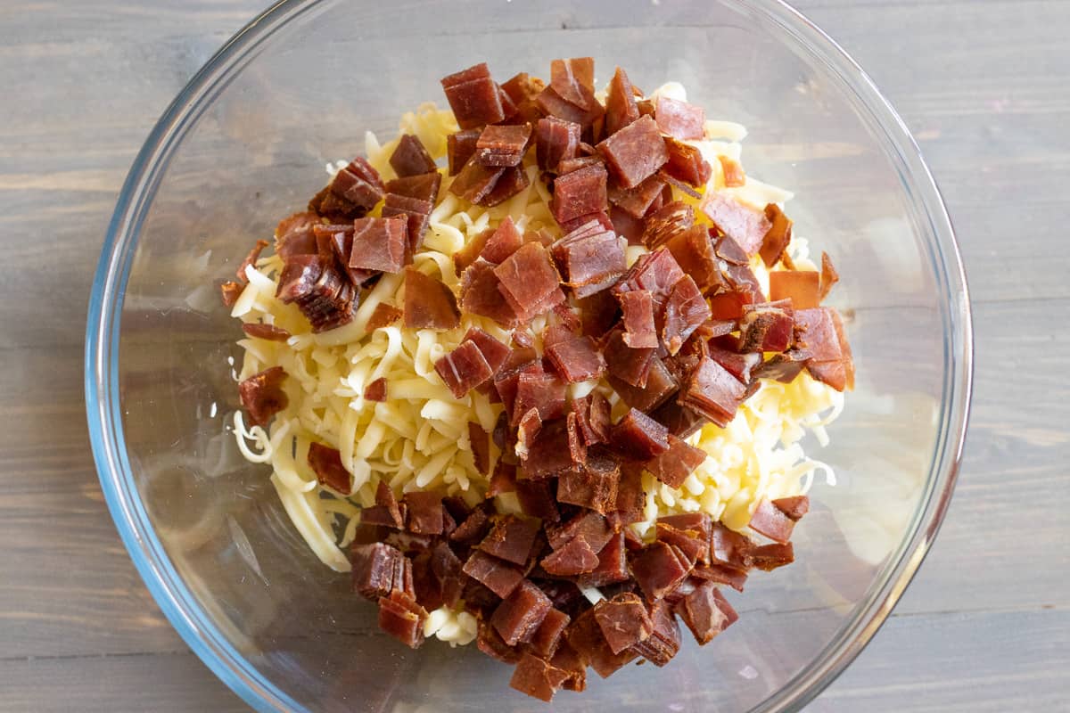 grated cheese and chopped pastirma are placed in a bowl