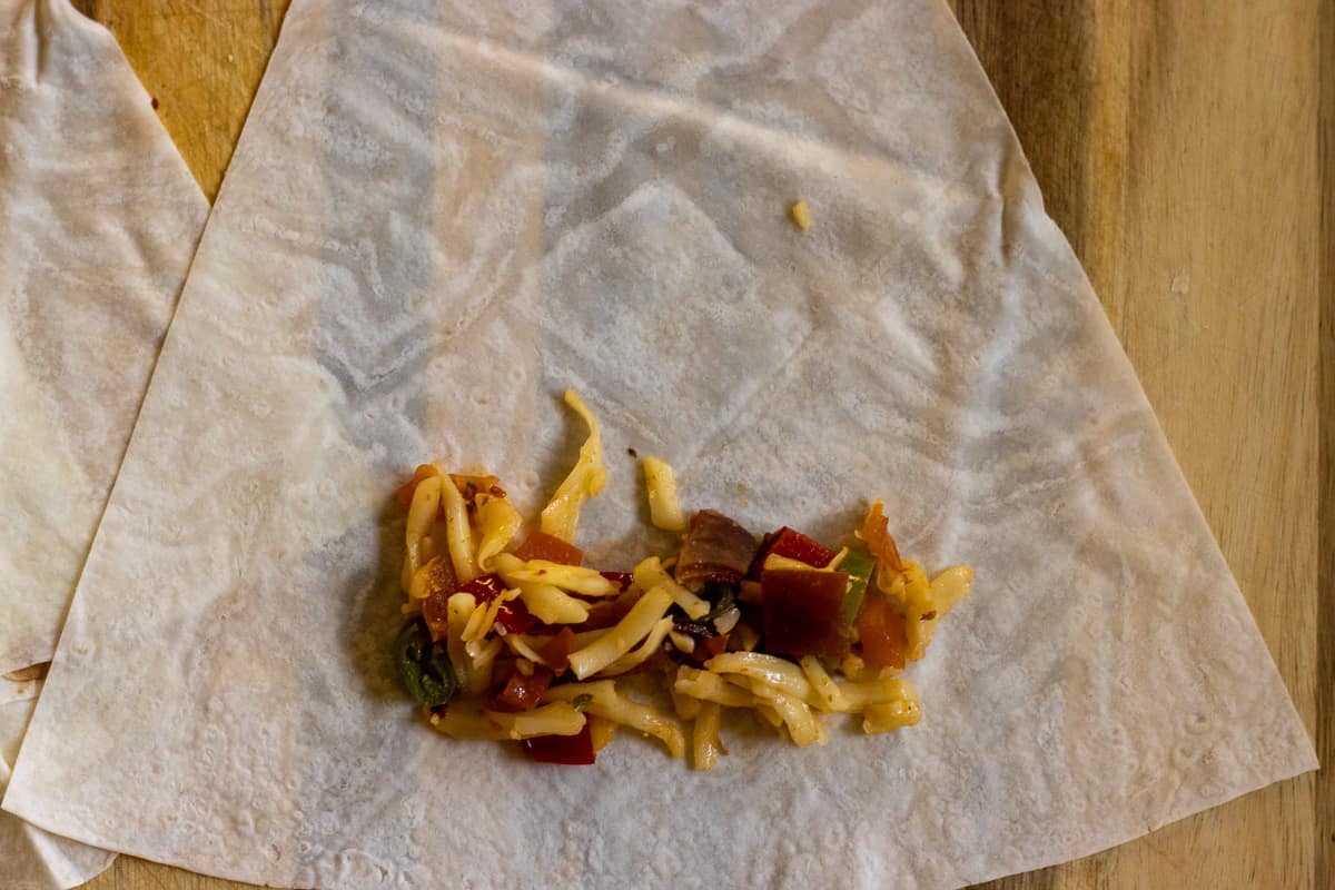 a tablespoon of filling is placed on the large side of the triangle