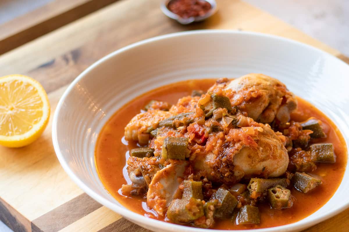 bamya served in a plate with lemon and chili on the side