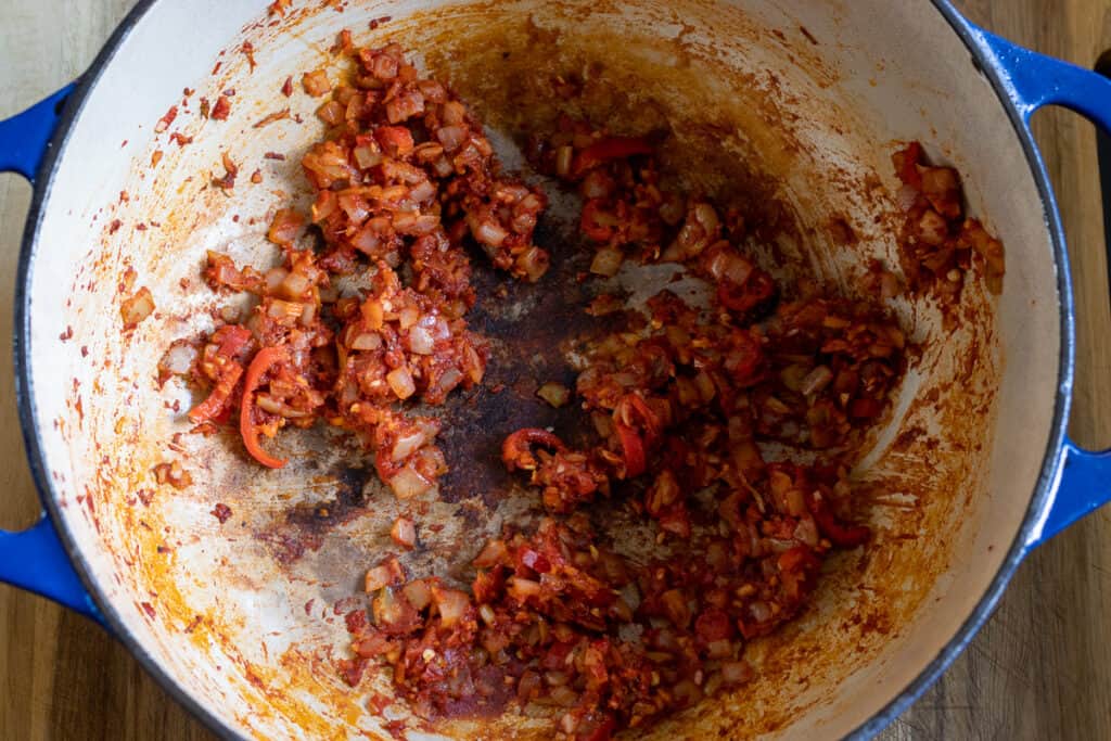 Garlic and tomato paste are added to sautéed onions.