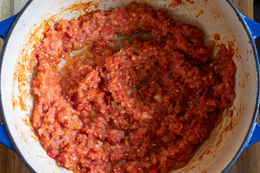 Grated tomatoes are added to the pot.